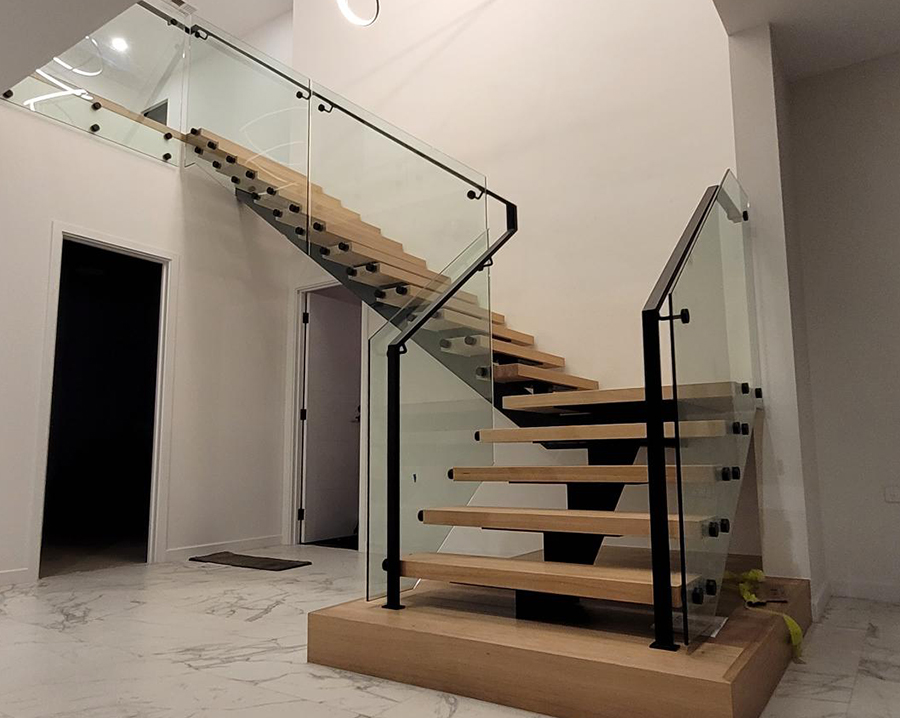 Custom architectural glass balustrade, handrail and steel staircase fabricated and installed by the team at Absolute Metal Fabrications.